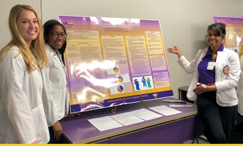 Nursing students posing by their poster presentations.