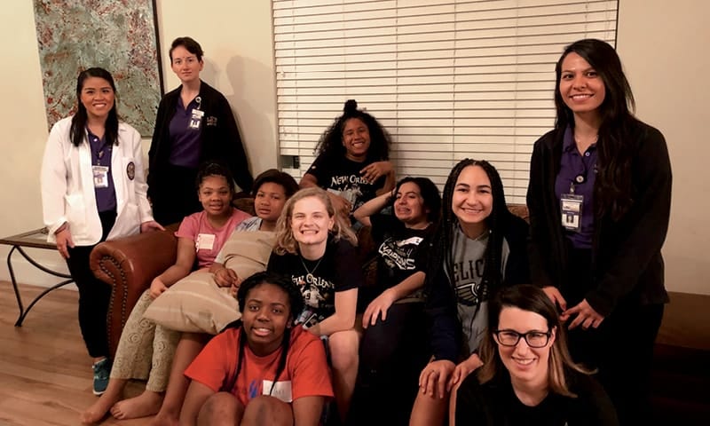 Nursing students sitting with a group of teenagers,