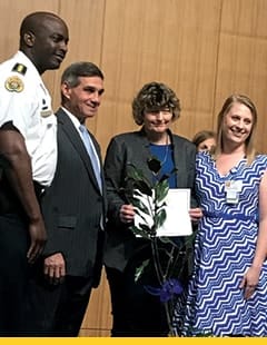 Randy Rosamond holding her award and standing with three others from the New Orleans Children’s Advocacy Center.
