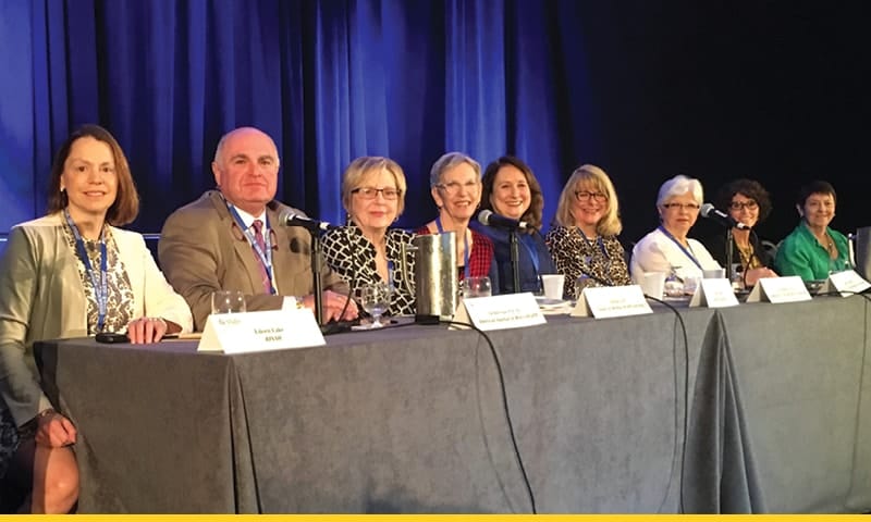 Nine people doing a presentation. A sign that reads Southern Nursing Research Society is displayed on a podium near the group. Dr. Demetrius Porche is second from left in front of a microphone.