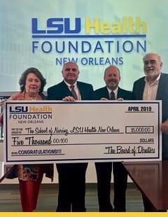 four people holding a cardboard check and standing in front of a banner that reads LSU Health Foundation New Orleans. The check features the LSU Health Foundation New Orleans logo. It is payable to The School of Nursing LSU Health New Orleans for $5000.