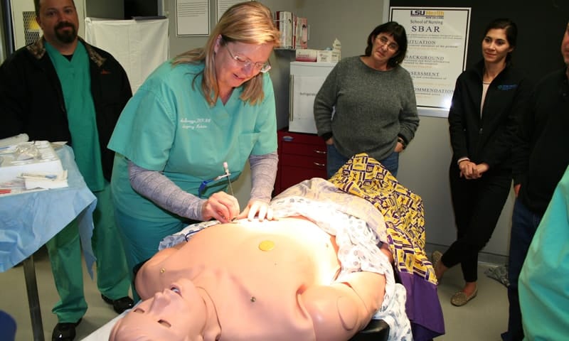 Nurse performing demonstration on medical dummy