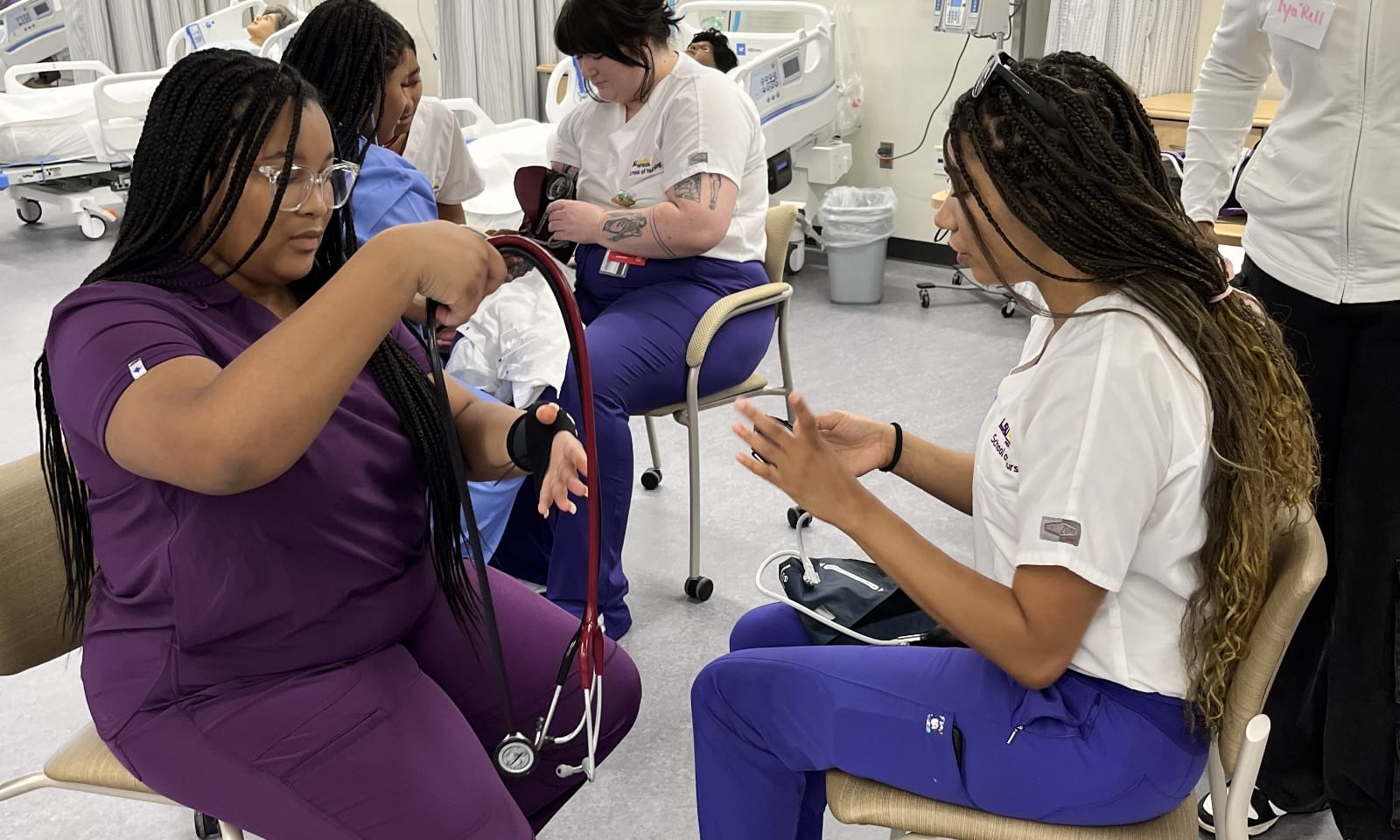 New nursing students work together on an anatomy simulation table.