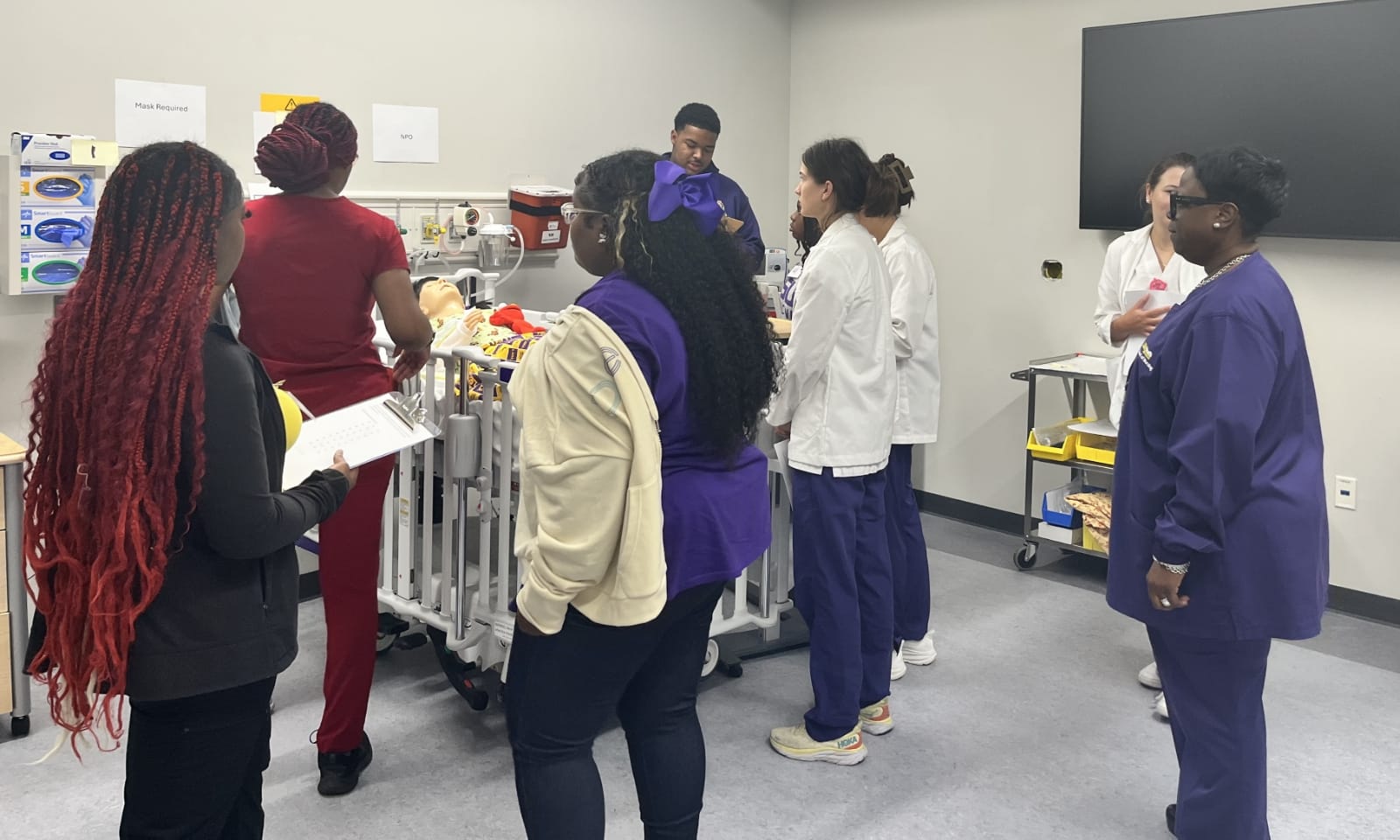 New nursing students work together on an anatomy simulation table.