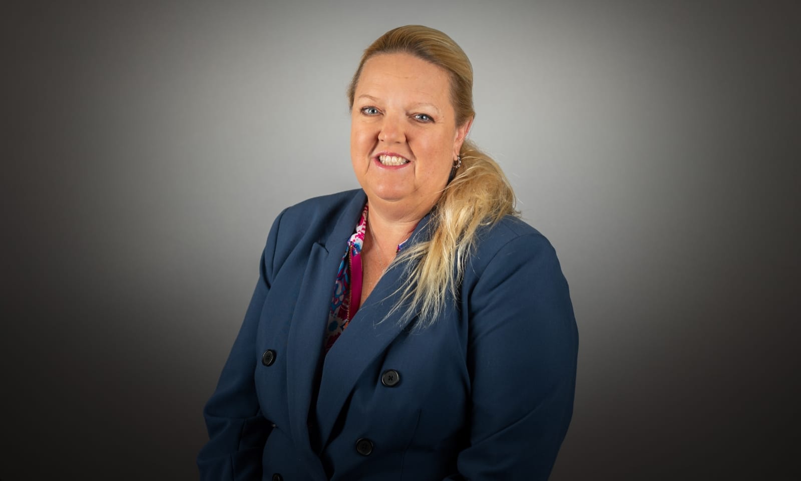 A woman smiles for the camera in a headshot photo.