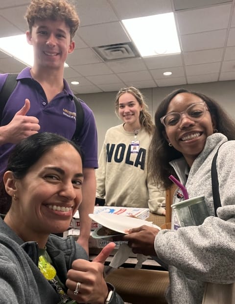 Four college students smile at the camera.